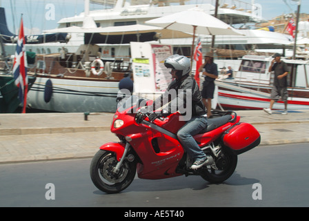 St Tropez waterfront motor bike rider hot summers day Stock Photo