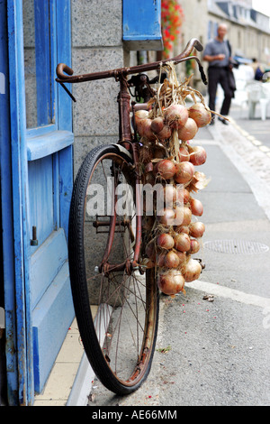An onion seelers bike ouside a traditional french creperie in the Brittany coastal town of Roscoff Stock Photo