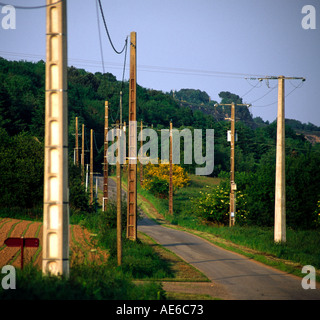 Telegraph and electricity poles on a deserted country road in Brittany France Stock Photo