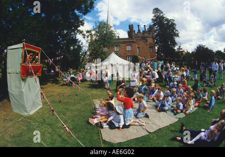 Children enjoying traditional Punch Judy show Hadleigh summer fete in The Deanery gardens Hadleigh Suffolk Stock Photo