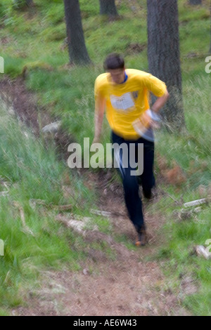 Orienteering National week running in Crathe woods competition young male running using ordanace survey guide compass navigating Stock Photo