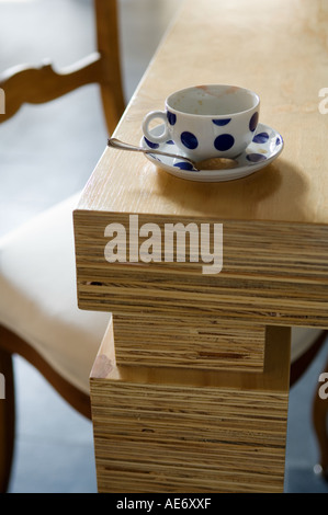 polka dot tea or coffee cup on edge of wooden design table Stock Photo