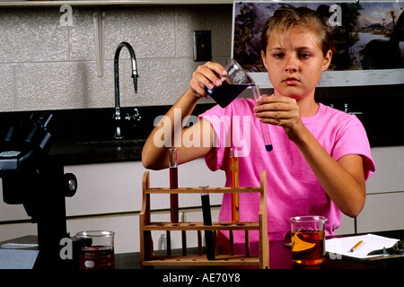 Student girl age 13 in Eighth grade learning science learning at lab desk Stock Photo