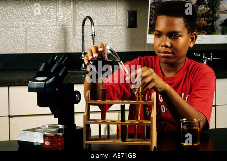 Black boy student age 13 in Eighth grade learning science at lab desk Stock Photo