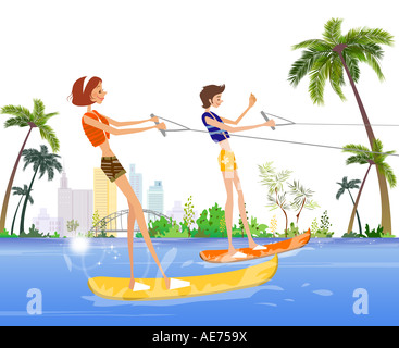 Side profile of a man and a woman waterskiing in the sea Stock Photo