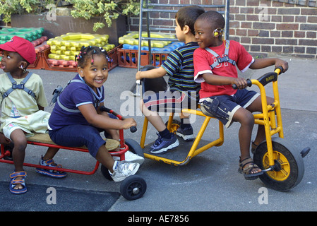 Nursery school children playing with toys in playground Stock Photo