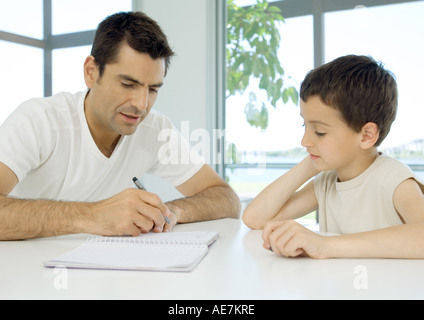 Man helping son with homework Stock Photo
