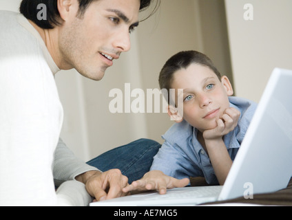 Man and boy using laptop together Stock Photo