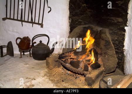 dh Shetland croft house museum SOUTHVOE SHETLAND Farmhouse open fireplace kettle pots peat fire burning hearth heritage cottage interior island farm Stock Photo