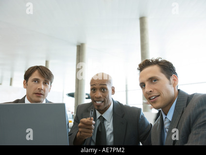 Three businessmen talking in airport Stock Photo