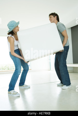 Couple moving armchair together Stock Photo