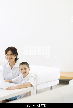 Boy and mature woman using laptop