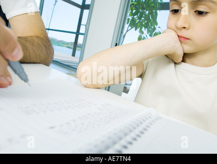 Boy doing homework with father's help, cropped Stock Photo