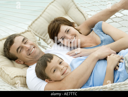 Family lying in hammock, smiling Stock Photo