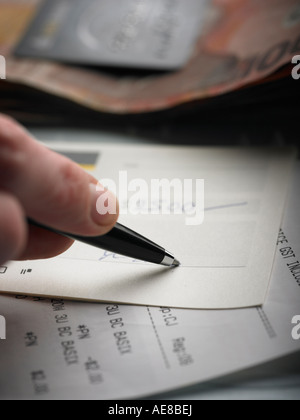 person signing check for cash and paying bill Stock Photo
