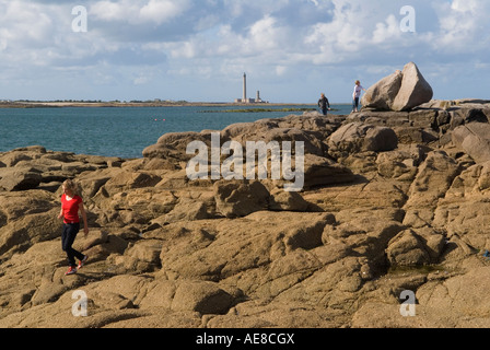 Barfleur Normandy France Children on holiday playing on rocks with lighthouse in background 2007 HOMER SYKES Stock Photo
