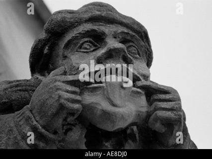 Guild Chapel Tower, Stratford Upon Avon, UK: Grotesque carving of man sticking out his tongue showing a pustulous Plague boil Stock Photo