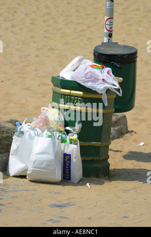 Overflowing rubbish bin on the beach Stock Photo