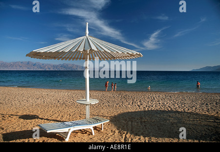 Red Sea coast at Nuweiba Sinai Egypt Arabian Mountains across the straits Beach chair and parasol Vacation photo Middle East Stock Photo