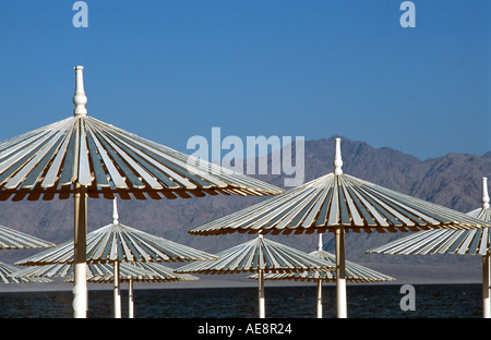 Red Sea coast at Nuweiba Sinai Egypt Arabian Mountains across the straits Parasols Vacation photograph Middle East Stock Photo