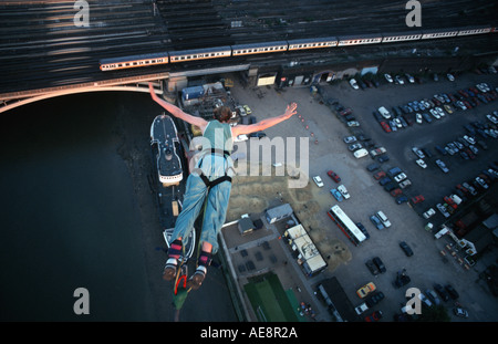 Bungie jumping from a crane high above the river Thames London England Stock Photo