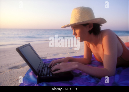 Woman on beach working on laptop computer in the Maldives Model released image Stock Photo