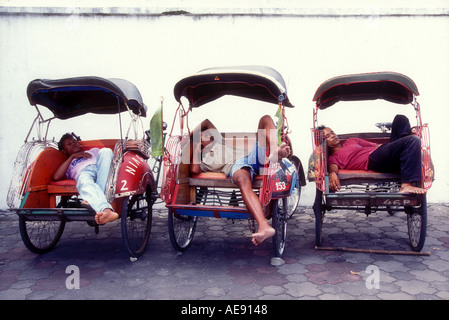 Sleeping becak pedicab drivers in Jogjakarta Java Indonesia Southeast Asia Model released image Stock Photo