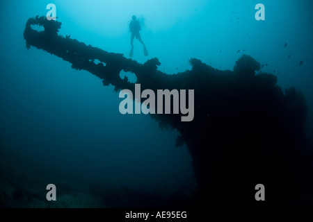 A diver hovers over the bow sprit of a Japanese ship sunk during World War II in Palau. Stock Photo