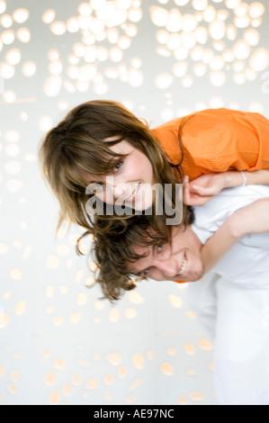 Young man carrying woman on his back, smiling for the camera Stock Photo