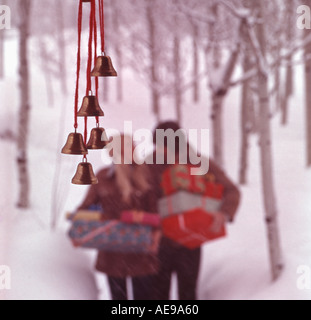 Couple carrying Christmas presents in a snowy scene Stock Photo