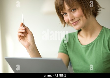 Young woman using laptop computer, smiling for the camera Stock Photo