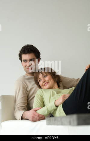 Smiling couple lying on a sofa Stock Photo