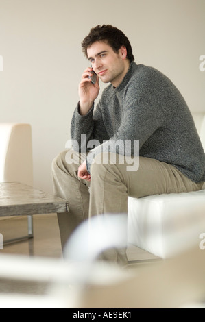 Man sitting on a sofa using a mobile phone Stock Photo