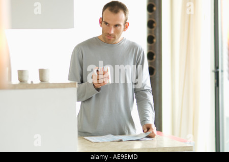 Man standing in the kitchen, holding mug Stock Photo