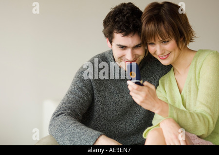 Smiling couple looking at mobile phone Stock Photo