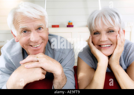 Senior couple lying on bed, smiling for the camera Stock Photo