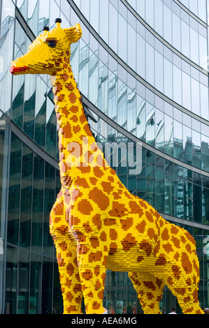 large figure TOY Giraffe made of lego brick ahead of SONY CENTER BERLIN glass facade