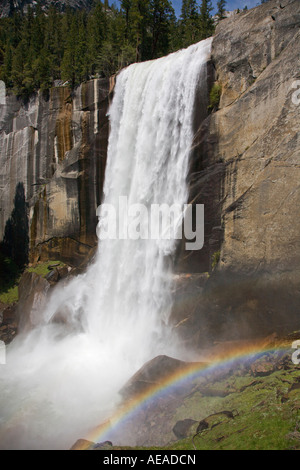 A rainbow forms from the mist of VERNAL FALLS which drops 317 during the SPRING run off YOSEMITE NATIONAL PARK CALIFORNIA Stock Photo