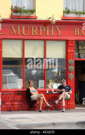 murphy's bar Macroom Ireland - two people sitting at table outside pub enjoying pints of beer on a warm sunny afternoon in june Stock Photo
