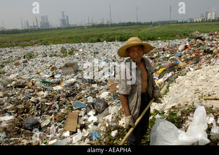 migrant worker collects plastics from a garbage dump China June 12 2006 Stock Photo