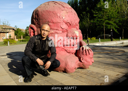 Yang Shaobin, chinese contemporary artist, poses in front of his sculpture work, in his studio in Songzhuang of Beijing, China. Stock Photo