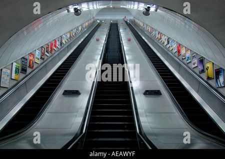 Advertisement lined Escalator wall in london underground Stock Photo