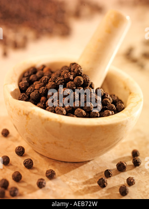 BLACK PEPPERCORNS IN PESTLE AND MORTAR Stock Photo
