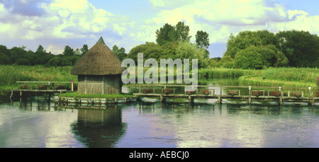 River Test at Longstock. Eel traps thatched fisherman shelter on wooden bridge over river Test August Stock Photo