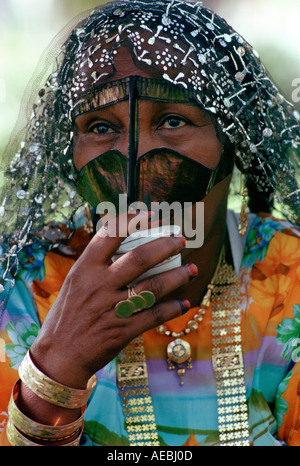 Bedouin woman drinking from a cup Abu Dhabi Stock Photo