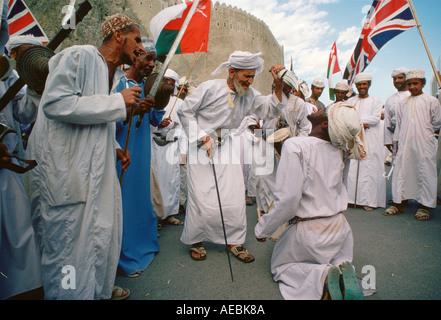 Man acting out cutting off another man s tongue in a performance outside Sultan Qaboos Royal Palace Muscat Oman Stock Photo