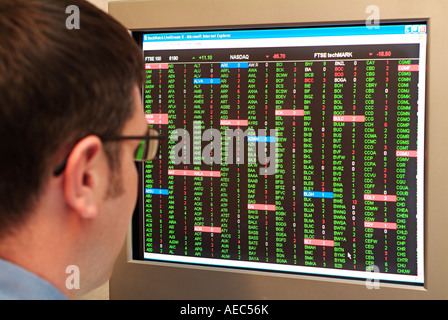 Stock Trader Looking at a Monitor Screen Full of Share Prices Stock Photo