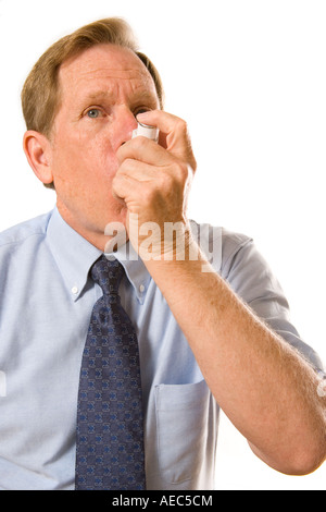 Middle aged man using Inhaler to deliver medication. Stock Photo