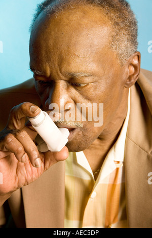 Elderly man using an asthma inhaler. Stock Photo