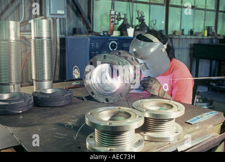 A union welder using an arc welder welds pipes in together in a shop in Little Rock Arkansas Stock Photo
